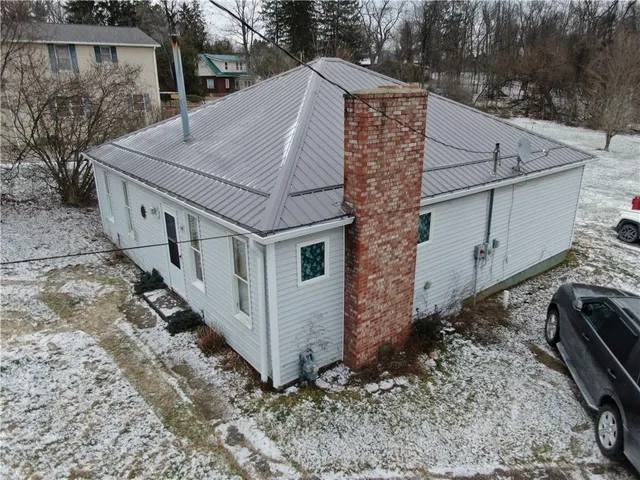 a aerial view of a house with a yard and large tree
