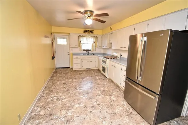 a kitchen with granite countertop a refrigerator a stove a sink and dishwasher