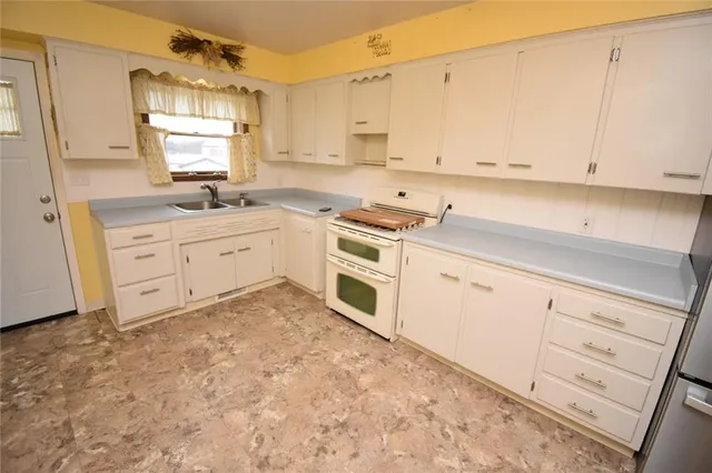 a kitchen with granite countertop white cabinets sink and stainless steel appliances