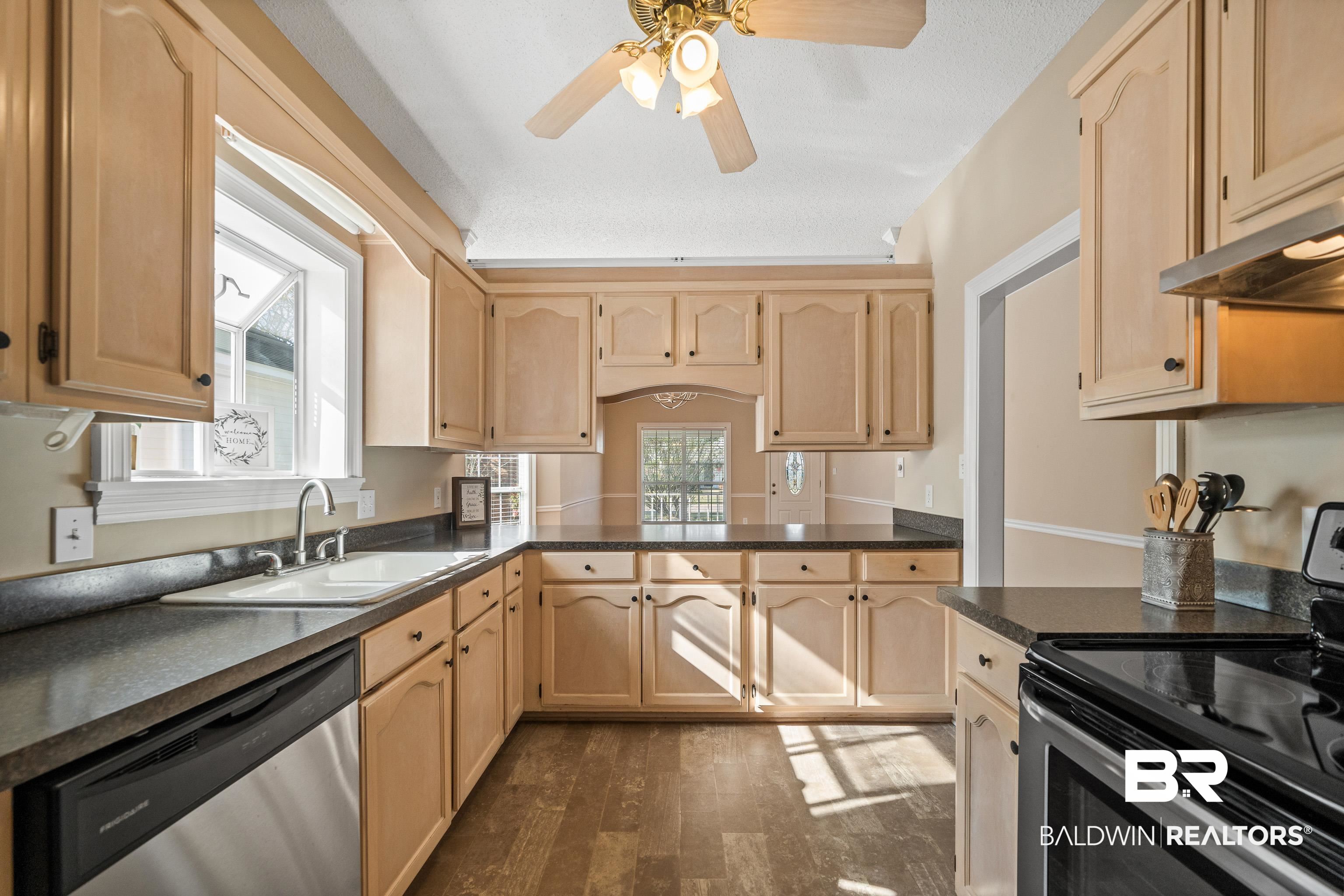 27 Cottage Drive Fairhope, AL 36532 - Photo 12 of 33 Kitchen with stainless steel appliances, light brown cabinetry, ceiling fan, dark wood finished floors, and a peninsula