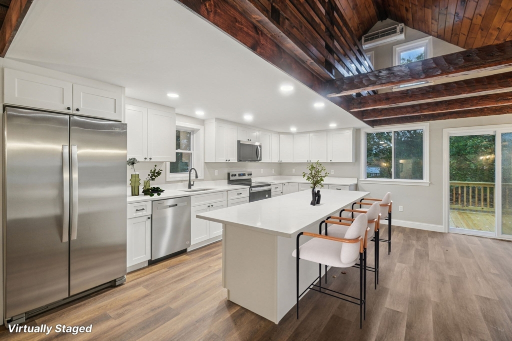 a kitchen with a sink a refrigerator and wooden floor