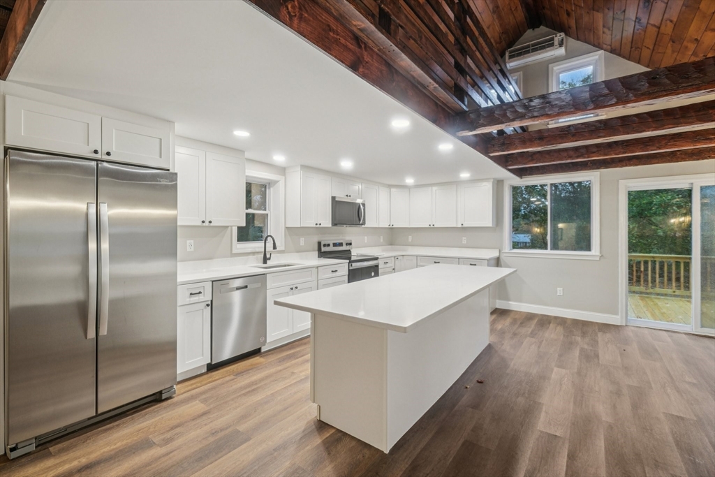1 Rounseville Road Rochester, MA 02770 - Photo 19 of 42 a large kitchen with a center island wooden floor stainless steel appliances and windows