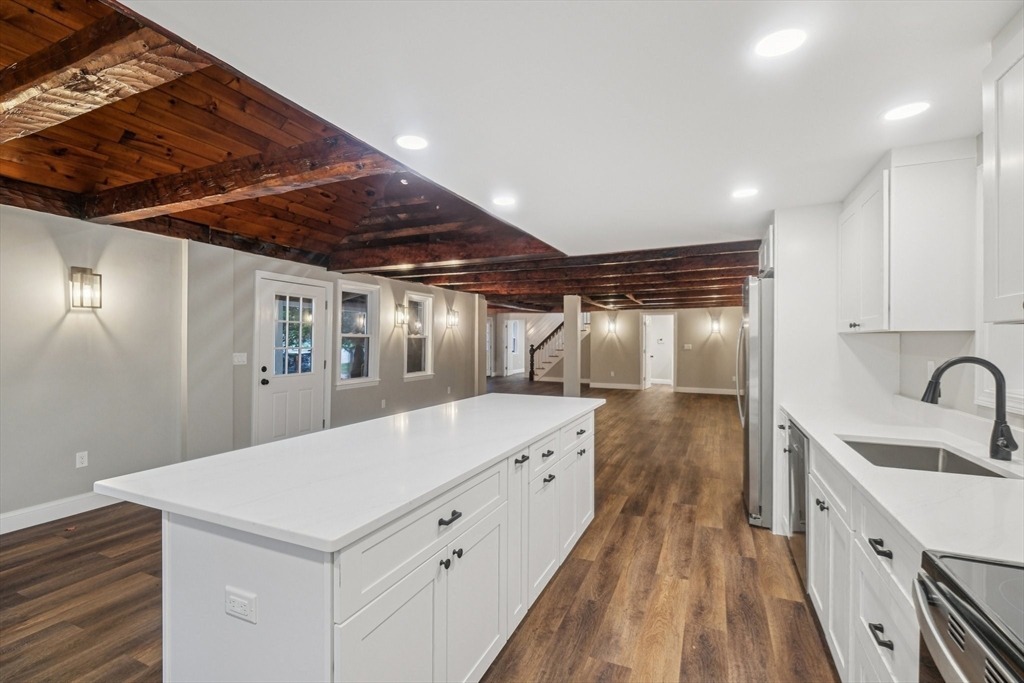 1 Rounseville Road Rochester, MA 02770 - Photo 21 of 42 a large white kitchen with a sink and wooden floor