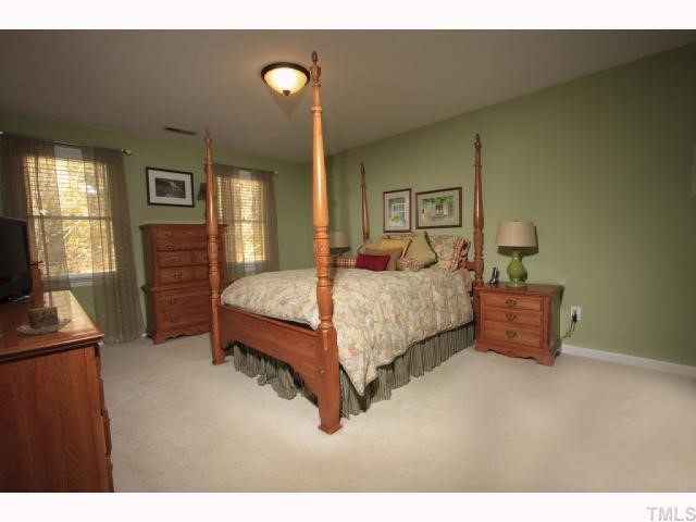 8305 Morgans Way Raleigh, NC 27613 - Photo 6 of 12 a bedroom with a bed and wooden floor