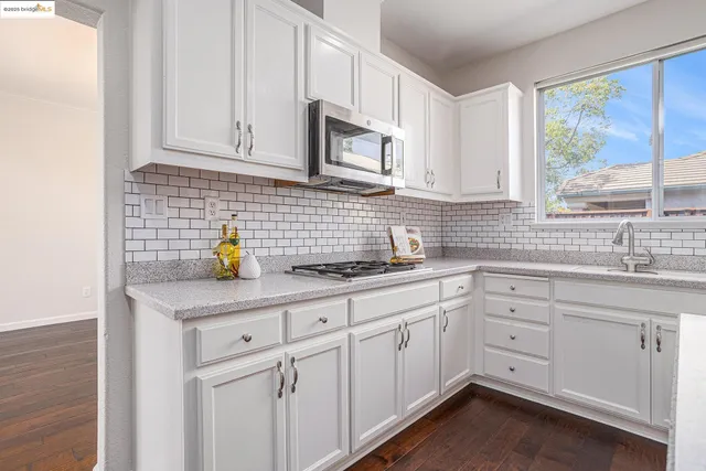 a kitchen with white cabinets and appliances