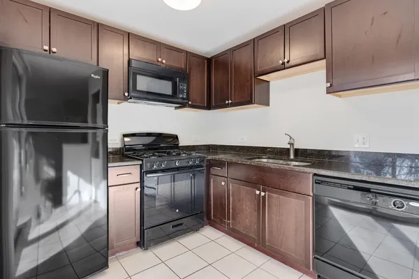 a kitchen with stainless steel appliances granite countertop a refrigerator sink and stove