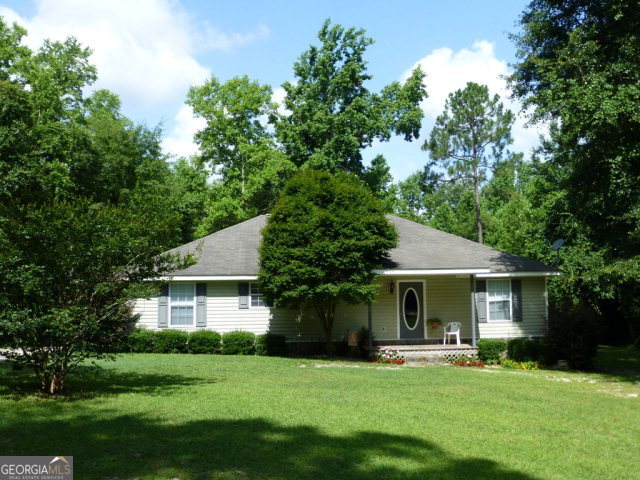 418 Red Fox Road Baxley, GA 31513 - Photo 1 of 1 a front view of a house with a garden and trees