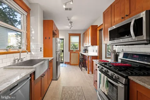 a kitchen with stainless steel appliances a stove a sink and a microwave