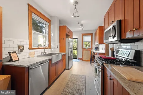 a kitchen with stainless steel appliances granite countertop a stove a sink and a refrigerator