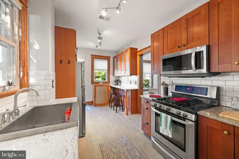 a kitchen with stainless steel appliances a stove a sink and a microwave