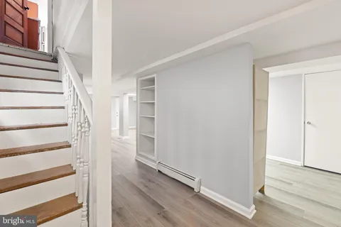 a view of a hallway with wooden floor and entryway