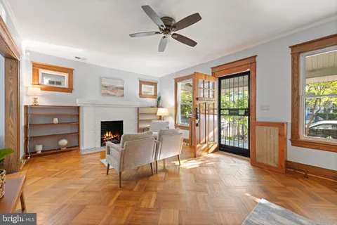 a living room with furniture a fireplace and a floor to ceiling window