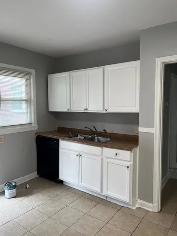 a kitchen with granite countertop white cabinets and sink