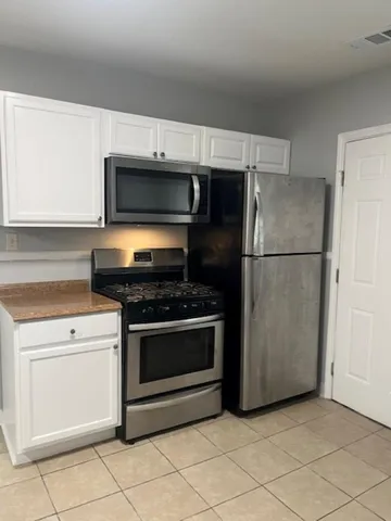 a kitchen with cabinets stainless steel appliances and a counter space