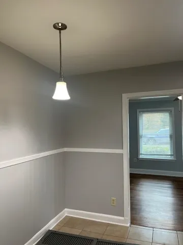 a view of empty room with window and wooden floor