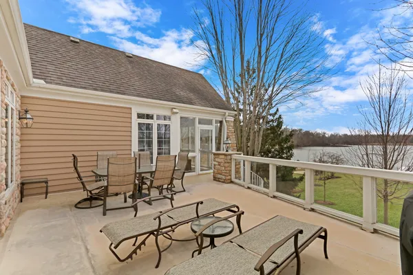 a view of a patio with table and chairs with wooden floor and fence