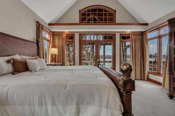 a spacious bedroom with a large bed and large windows