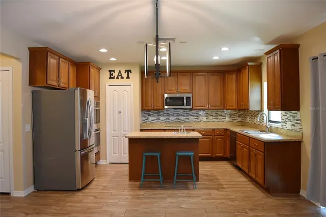 a kitchen with stainless steel appliances granite countertop a refrigerator a sink and a stove