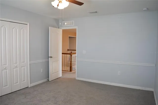 an empty room with a empty space and a ceiling fan