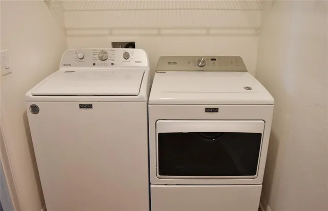 a white house that has tree in front of it