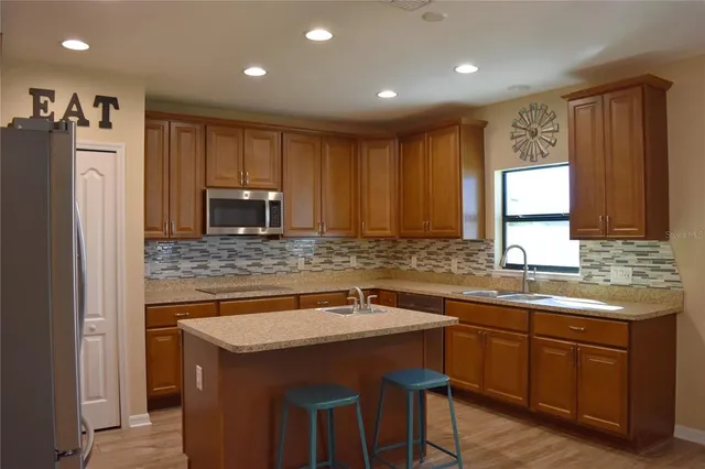 a kitchen that has a sink cabinets counter space and appliances