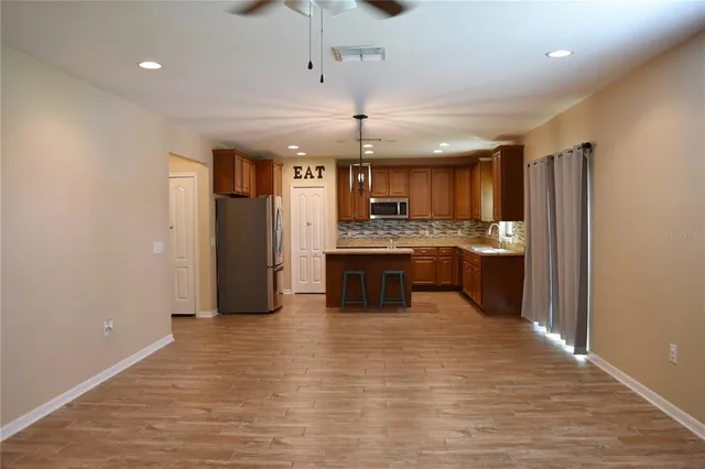a kitchen with stainless steel appliances granite countertop a stove refrigerator and cabinets