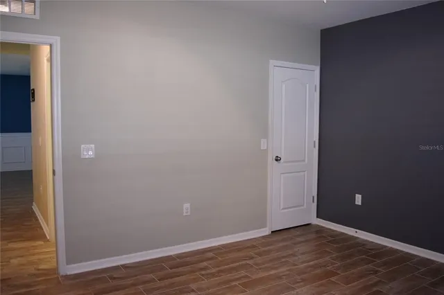 a view of an empty room with wooden floor