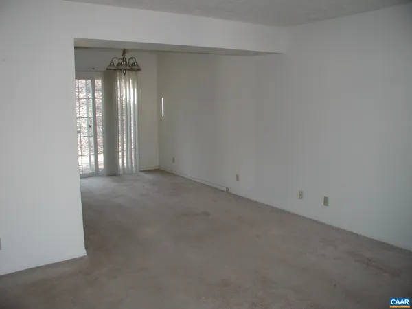 an empty room with stairs and wooden floor
