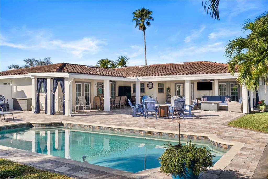 1896 Sailfish Road South St. Petersburg, FL 33707 - Photo 1 of 1 a view of a patio with couches chairs and swimming pool with a yard