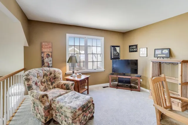 a living room with furniture a flat screen tv and a window