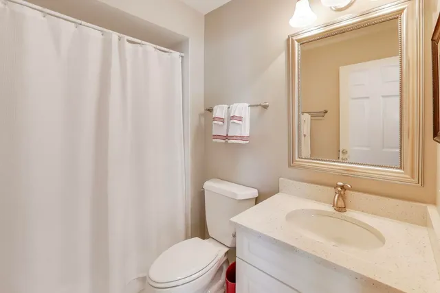 a bathroom with a sink a toilet and shower curtain