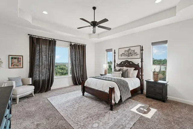 a spacious bedroom with a bed a chandelier and a couch