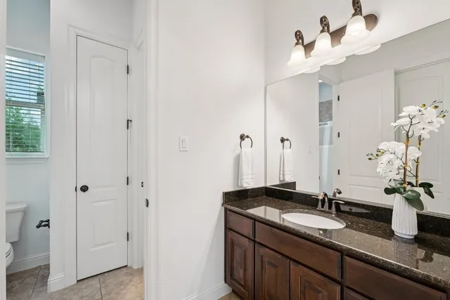 a bathroom with a granite countertop sink and a mirror