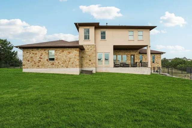 a front view of a house with a garden and statue