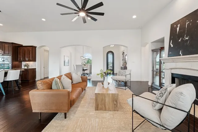 a living room with fireplace furniture and a view of kitchen