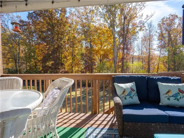 a balcony with wooden floor and outdoor seating