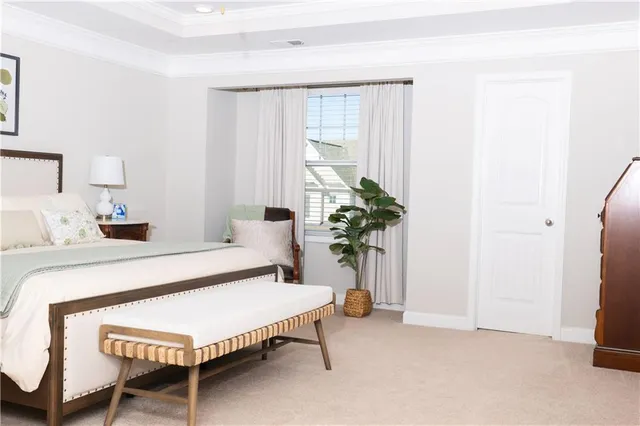a bedroom with a bed table and a potted plant