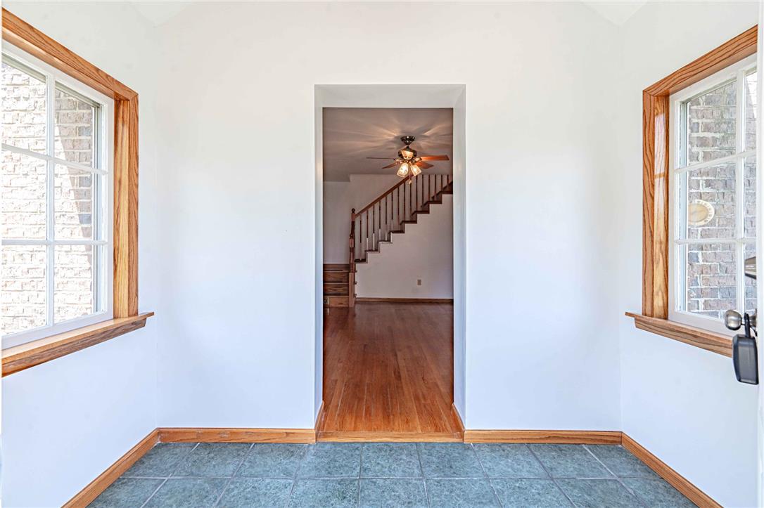 4165 East Texas Road Allentown, PA 18103 - Photo 7 of 56 A welcoming entryway with natural wood trim framing bright windows, leading to an inviting staircase.