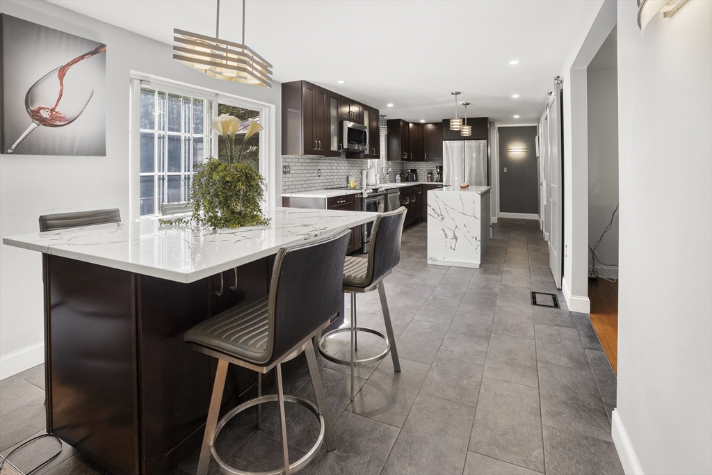 138 Walnut Street Douglas, MA 01516 - Photo 6 of 32 a kitchen with stainless steel appliances kitchen island granite countertop a table chairs and a refrigerator