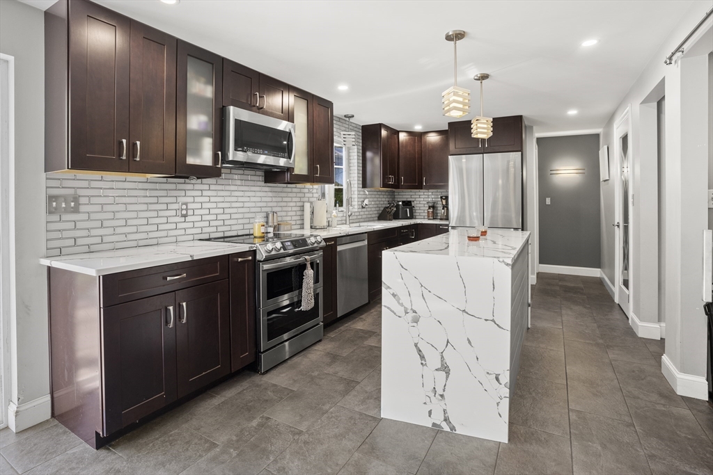138 Walnut Street Douglas, MA 01516 - Photo 9 of 32 a kitchen with stainless steel appliances a stove sink microwave refrigerator and cabinets
