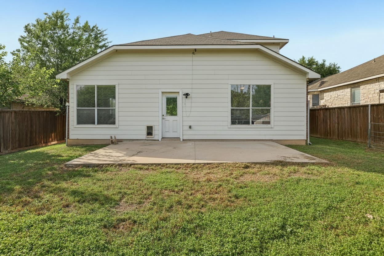 1721 Long Rifle Drive Austin, TX 78754 - Photo 30 of 38 A spacious backyard with a generous concrete patio offers abundant space for outdoor enjoyment.