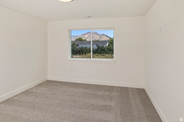 612 North 400 West Logan, UT 84321 - Photo 20 of 27 Room with neutral carpeting and white painted walls, featuring a window with a mountain backdrop