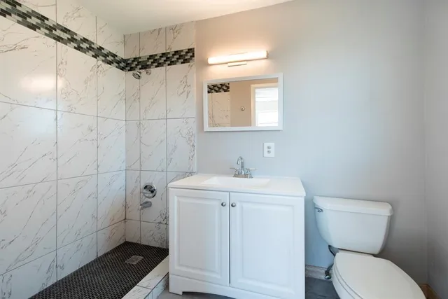 a bathroom with a sink a toilet and shower