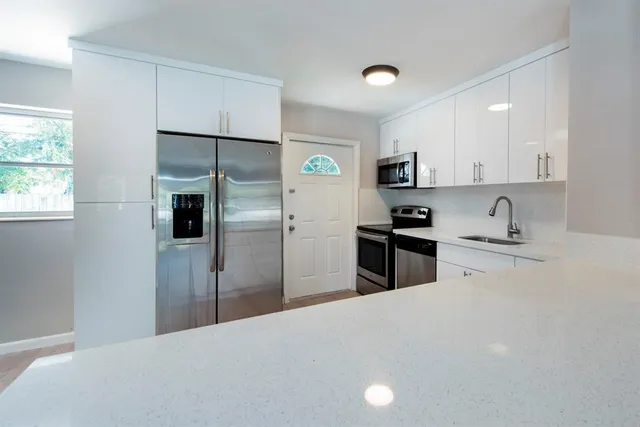 a kitchen with a refrigerator a stove top oven a sink and dishwasher