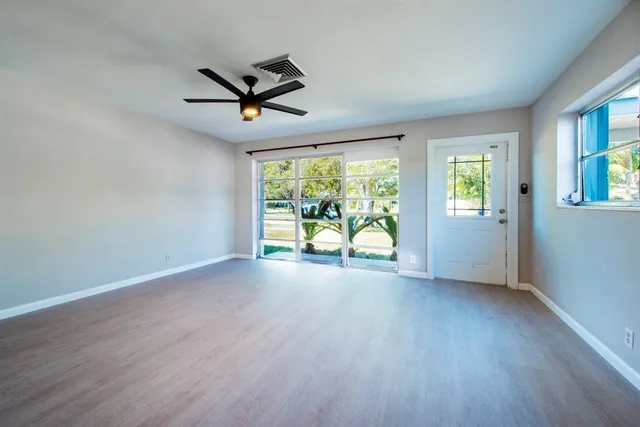 a view of room with window ceiling fan and hardwood floor