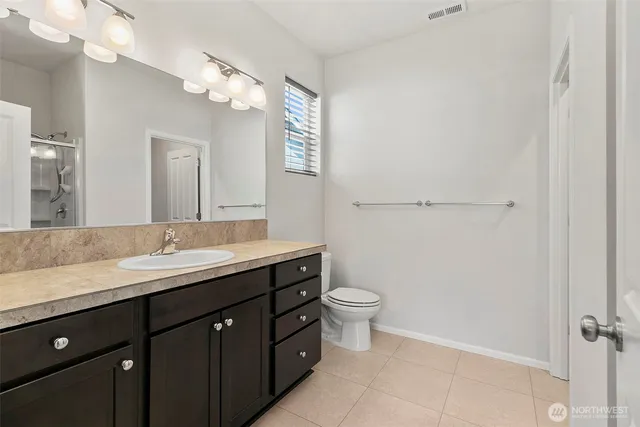 a bathroom with a granite countertop sink a toilet and a mirror