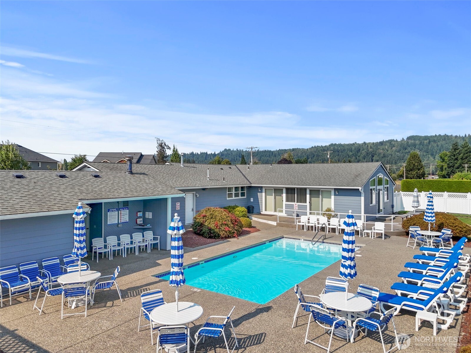103 Hickory Avenue Southwest, Unit 35 Orting, WA 98360 - Photo 30 of 38 a view of a patio with couches table and chairs under an umbrella