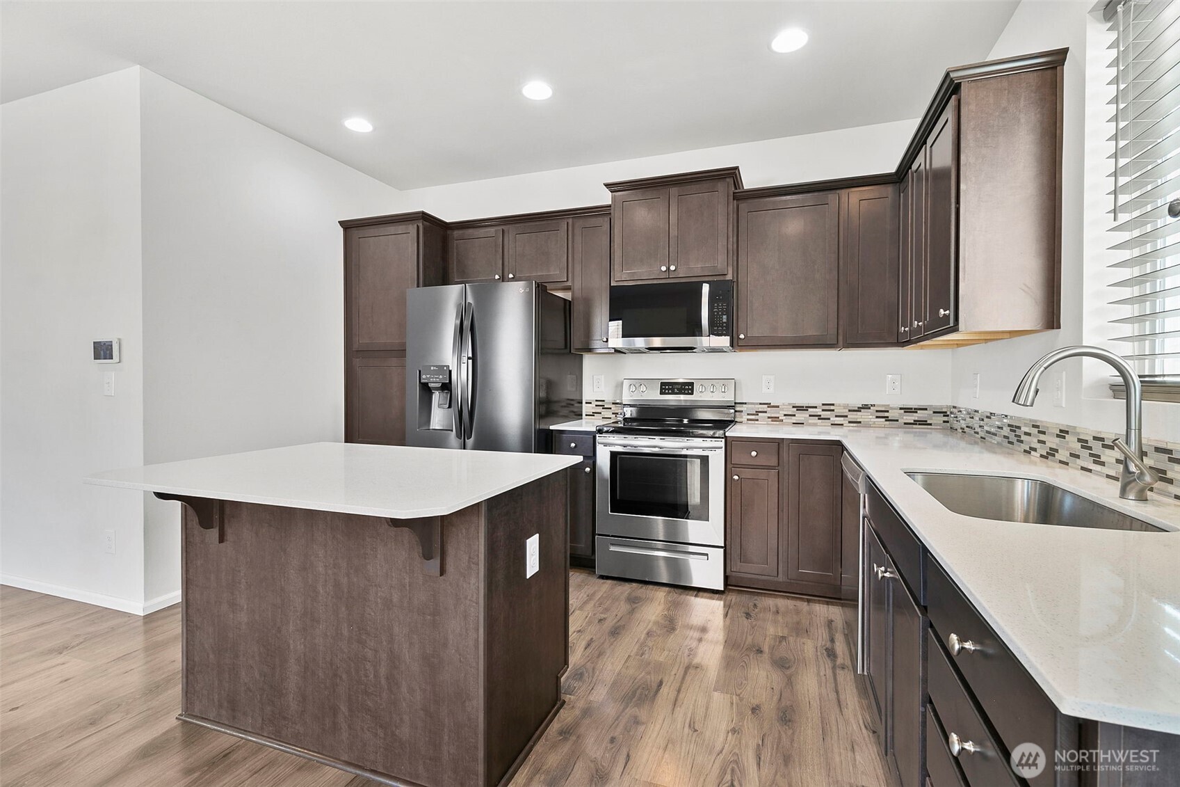 103 Hickory Avenue Southwest, Unit 35 Orting, WA 98360 - Photo 4 of 38 a kitchen with stainless steel appliances a sink stove refrigerator and cabinets