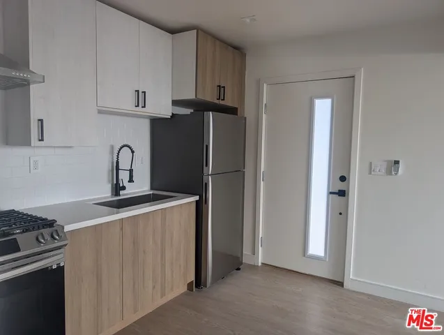 a kitchen with stainless steel appliances granite countertop a refrigerator and a stove