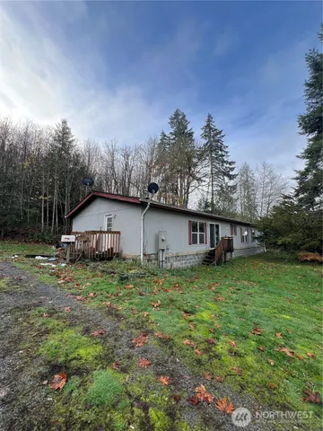a house is sitting in middle of the green field